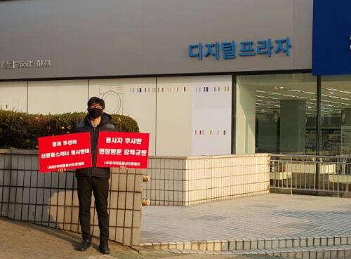 지난해 11월17일 최성준 방통위원장이 신분증 스캐너 도입 현황 점검차 방문한 한 매장 앞에서 전국이동통신유통협회 관계자가 '문제 투성이 신분증 스캐너 결사 반대' '종사자 무시한 현장 방문 강력 규탄'이라는 팻말을 들고 시위하고 있다. ⓒ 전국이동통신유통협회