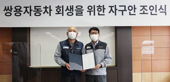 정용원 관리인(사진 오른쪽)과 정일권 노동조합 위원장이 합의안에 서명한 후 기념촬영을 하고 있는 모습. ⓒ 쌍용자동차