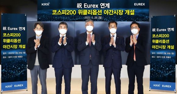 28일 Eurex 연계 코스피200위클리옵션 상장기념식에서 박찬수(왼쪽 두 번째) 한국거래소 파생상품시장본부장보, 조효제(가운데) 한국거래소 파생상품시장본부장, 이정의(오른쪽 두번째) 한국거래소 파생상품시장본부장보가 기념촬영을 하고 있다.