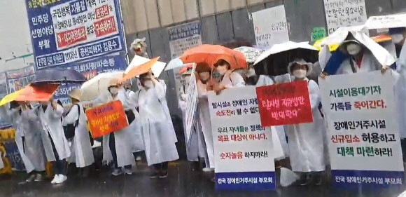 23일 소나기가 내린 상황에서도 장애인거주시설이용자부모회 측은 집회를 진행했다. = 박성현 기자