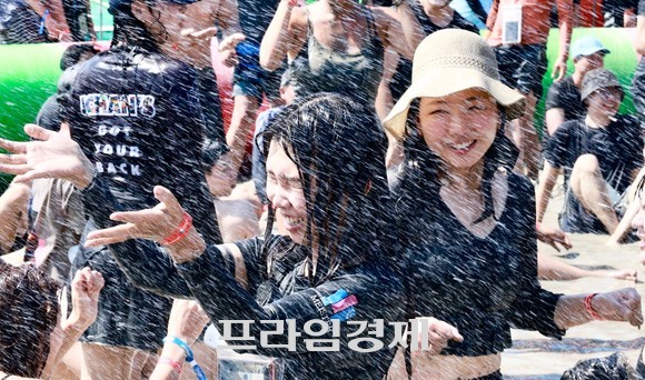 29일 보령 대천해수욕장 머드축제장에서 피서객들이 시원한 물줄기를 맞으며 신나는 머드몹신을 즐기고 있는 여성 피서객 모습. ⓒ 프라임경제