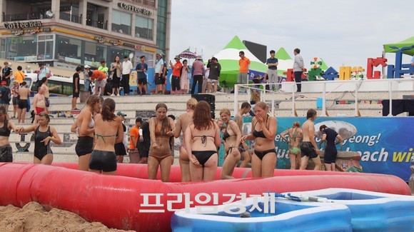 9일 대천해수욕장 머드광장 앞 해변에서 음악과 함께 신나게 춤추며 물세례를 받는 머드몹신과 머드 셀프마사지를 즐기고 해수욕을 만끽하고 있다. ⓒ 프라임경제
