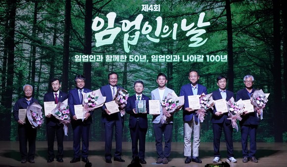 남성현 산림청장(왼쪽 다섯번째)이 1일 서울 여의도 국회 의원회관 대강당에서 열린 '제4회 임업인의 날 기념식'에서 100대 명품숲에 선정된 임업인들에게 명품숲 책자를 전달한 뒤 기념촬영을 하고 있다. ⓒ 산림청