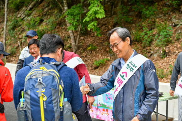 박남서 영주시장이 25일 삼가야영장 입구에서 진행된 등산객 맞이 행사에서 철쭉제 홍보물을 나눠주며 안전산행을 당부하고 있다. ⓒ 영주시