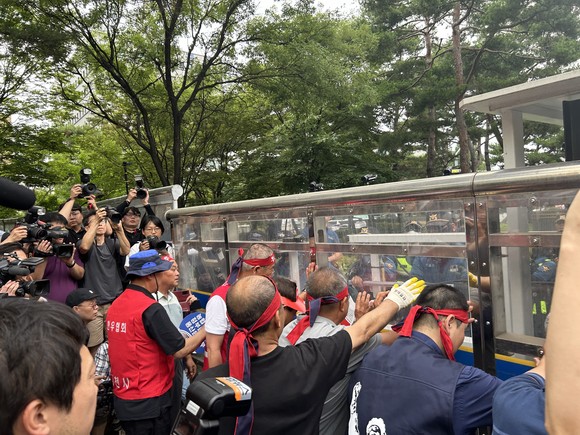 전국한우협회 회원들이 경찰이 설치한 차단벽을 밀며 투쟁하고 있다. =배예진 기자