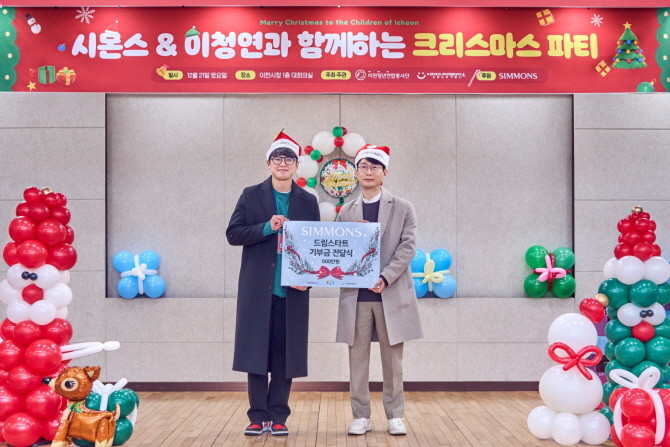 지난 21일 시몬스가 이천 지역 아동들에게 500만 원 상당의 크리스마스 선물을 전달했다. 사진은 이종성 시몬스 부사장(오른쪽)과 박대규 이천청년연합봉사단 단장. © 시몬스