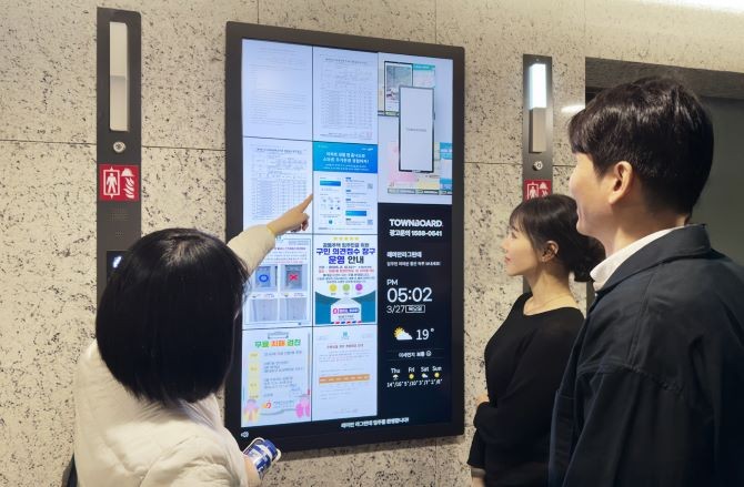 래미안 라그란데 입주민들이 아파트에 설치된 타운보드를 보고 있다. ⓒ KTis