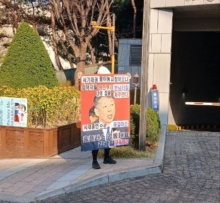 홈플러스 물품구매전단채 피해자가 김광일 MBK파트너스 부회장 겸 홈플러스 공동대표 자택 앞에서 1인 피켓시위 중이다. ⓒ 홈플러스 물품구매전단채 피해자비상대책위원회
