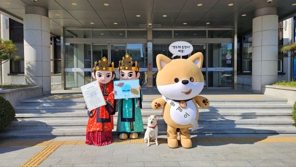 경주시청 본관 앞에서 경주시 공식 상징물로 지정된 캐릭터 '관이'(왼쪽), '금이'(가운데), '동경이'(오른쪽)와 천연기념물 제540호 '경주개 동경이'가 시민헌장과 참가자미 캐릭터 홍보물을 들고 포즈를 취하고 있다. ⓒ 경주시