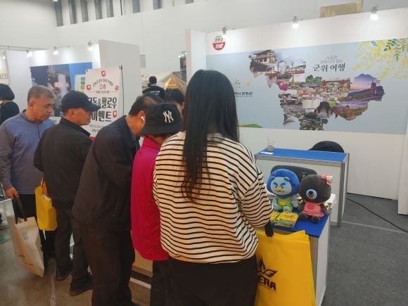 2025 대한민국 캠핑대전에 참가한 관람객들이 군위군 홍보부스를 둘러보고 있다. ⓒ 군위군