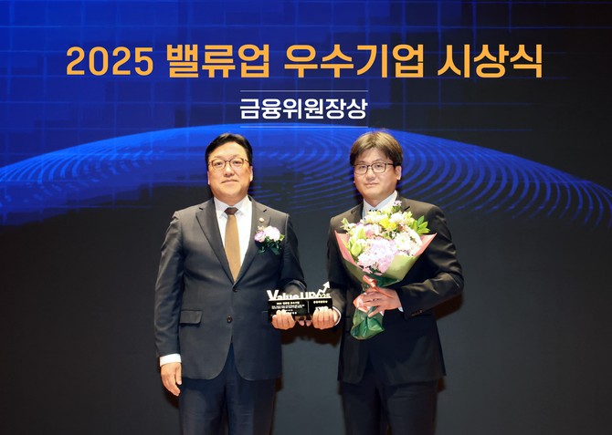 지난 27일 한국거래소에서 열린 '2025 밸류업 우수기업 시상식'에서 (왼쪽부터) 김병환 금융위원회 위원장과 장석훈 삼양식품 경영지원본부장이 기념 촬영을 하고 있다. ⓒ 삼양식품