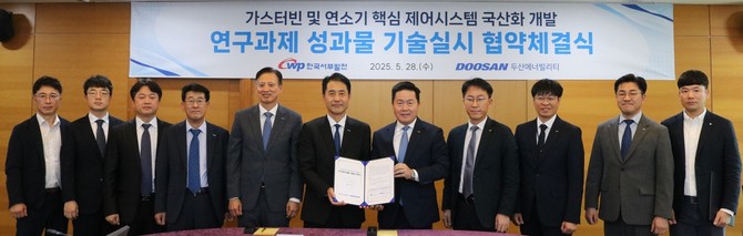 엄경일 서부발전 기술안전부사장(오른쪽 다섯번째)과 손승우 두산에너빌리티 파워서비스 부사장(여섯번째) 등이 참석자들과 기념촬영을 하고 있다. ⓒ 서부발전