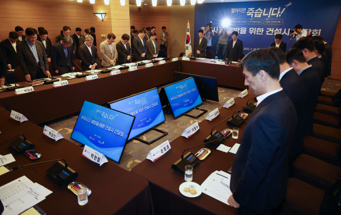 지난 23일 김영훈 고용노동부 장관이 '추락사고 예방을 위한 건설사 간담회'에서 건설사 대표이사들과 산재 사고 사망자를 위한 묵념을 하고 있다. © 연합뉴스