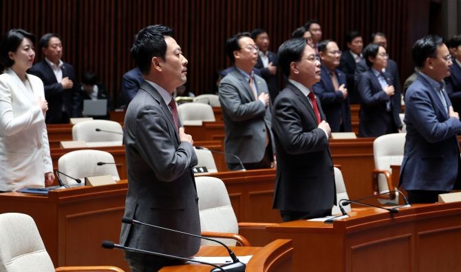장동혁 대표와 송언석 원내대표를 비롯한 국민의힘 의원들이 9일 국회에서 열린 긴급 의원총회에서 국기에 경례하고 있다. © 연합뉴스