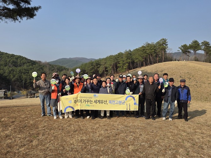 합천군이 합천군 고고가야주민수호단과 지역주민 등 50여 명이 참석한 가운데 세계유산 옥전 고분군의 가치와 의미를 널리 알리고 지역주민이 함께 가꾸는 세계유산, 옥전 고분군이라는 슬로건으로 환경정화 활동을 하고 기념촬영을 하고 있다. ⓒ 합천군