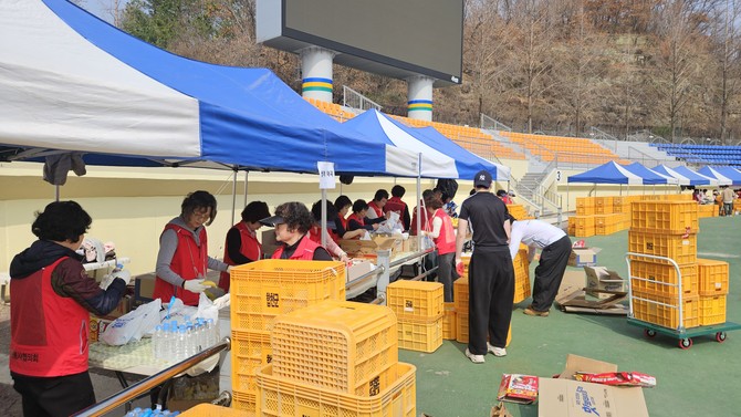 합천군 자원봉사협의회가 합천공설운동장에서 '제25회 합천벚꽃마라톤대회'의 원활한 운영을 지원하기 위한 간식포장 자원봉사활동을 하고 있다. ⓒ 합천군