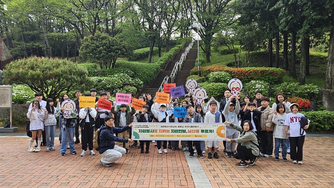 고성군이 남산공원 일원에서 청소년방과후아카데미 청소년과 학부모 40여 명이 참여한 가운데 '자원봉사로 지키는 자원안보 캠페인'을 실시하고 기념촬영을 하고 있다. ⓒ 고성군