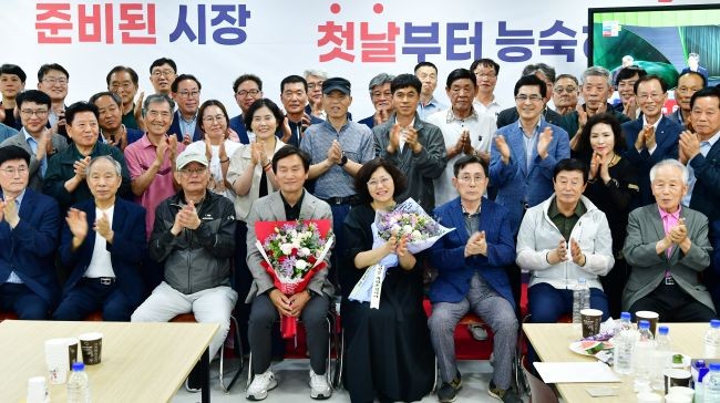 지지자들이 보낸 축하 꽃다발을 안고 있는 조현일 경산시장 당선인과 배우자 그리고 지지자들 단체 기념사진. ⓒ 조현일 캠프