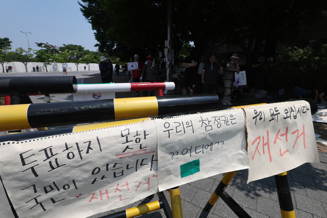6·3지방선거 투표용지 부족 사태로 촉발된 잠실 개표소 봉쇄 시위가 12일째 이어진 16일 서울 송파구 올림픽공원 핸드볼경기장 개표소 앞에 손팻말이 붙어있다. ⓒ 연합뉴스