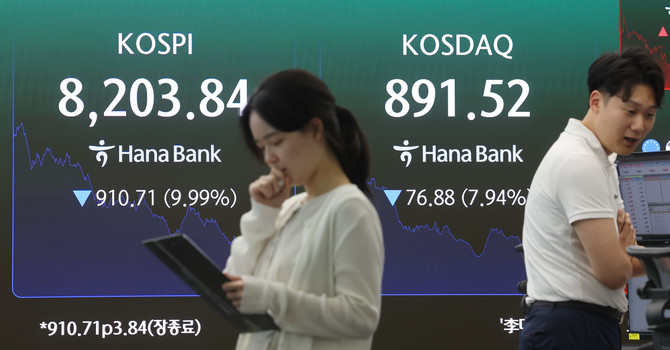 코스피가 10% 가까이 급락해 8200선을 간신히 지키며 마감한 23일 서울 중구 하나은행 딜링룸에서 직원이 업무를 보고 있다. ⓒ 연합뉴스
