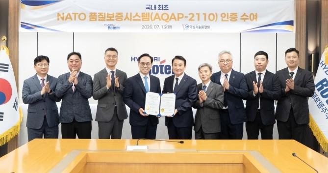 신상범 기품원장(왼쪽에서 다섯 번째), 이용배 현대로템 사장(왼쪽에서 네 번째) 등 관계자들이 지난 13일 현대로템 의왕 본사에서 나토 품질보증시스템 인증 수여식을 마친 후 기념촬영을 하고 있다. ⓒ 현대로템