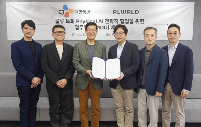 CJ대한통운과 리얼월드의 '물류특화 피지컬 AI 전략적 협업을 위한 업무협약 체결식'에 참석한 양사 관계자가 기념 사진을 촬영하고 있다. ⓒ CJ대한통운