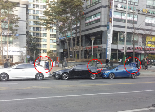 차량 트렁크를 열어 번호판을 위로 올라가게 해 주&middot;정차 감시 카메라를 피하고 있다. = 김경태 기자