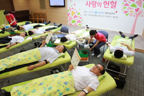  지난 20일 이순우 은행장(사진 앞줄 오른쪽)과 박원춘 노조위원장(앞줄 오른쪽 두번째)이 우리은행 본점에서 열린 '사랑의 헌혈' 캠페인에 참여해 헌혈을 하고 있다. ⓒ 우리은행